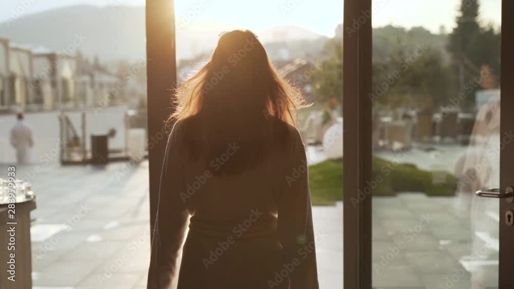 Young brunette walks out onto a rooftop pool deck during sunrise Young brunette walks out onto a rooftop pool deck during sunrise