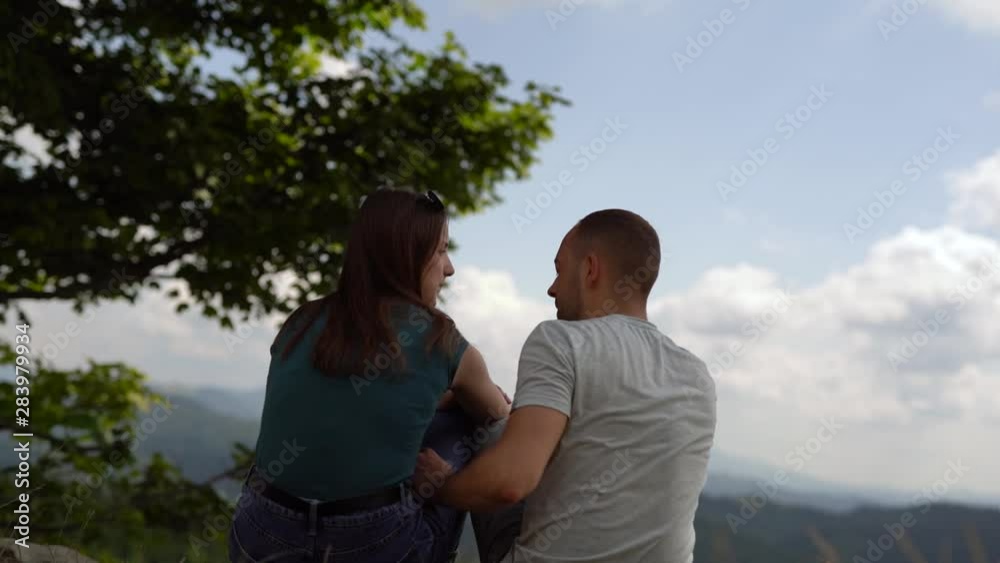 Young couple met at a scenic mountain location, cuddle and kiss Young couple met at a scenic mountain location, cuddle and kiss