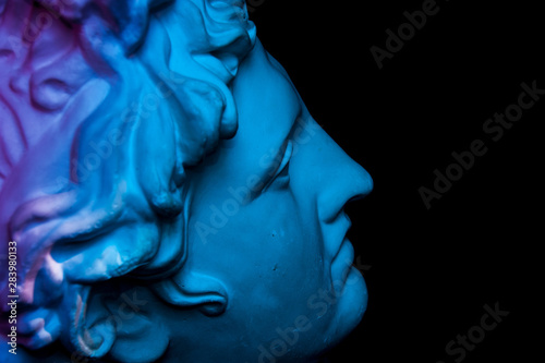 Gypsum copy of ancient statue Apollo head isolated on black background. Plaster sculpture man face.
