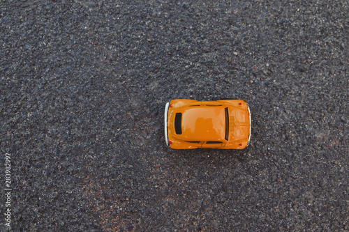 Top view shot of orange toy car on clean background.