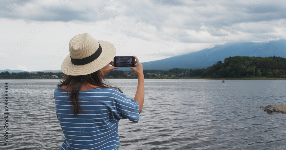 Woman take photo on cellphone in Fujisan