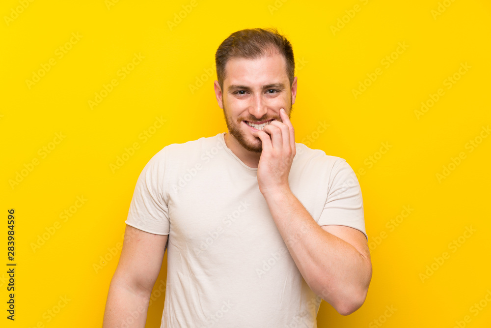 Handsome man over yellow background nervous and scared Handsome man over yellow background nervous and scared