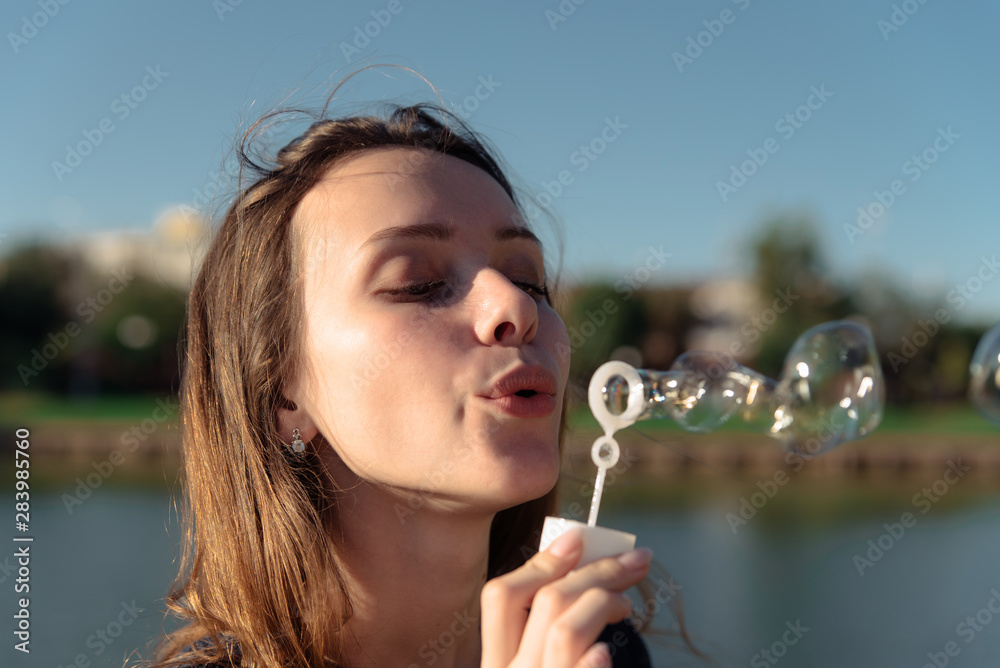 Portrait of a young beautiful woman in a dress blowing bubbles Portrait of a young beautiful woman in a dress blowing bubbles