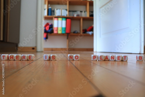 Wooden orange and white letters dice forming the slogan  THERE IS NO PLANET B  on wood background. Sentences against global warming  banner