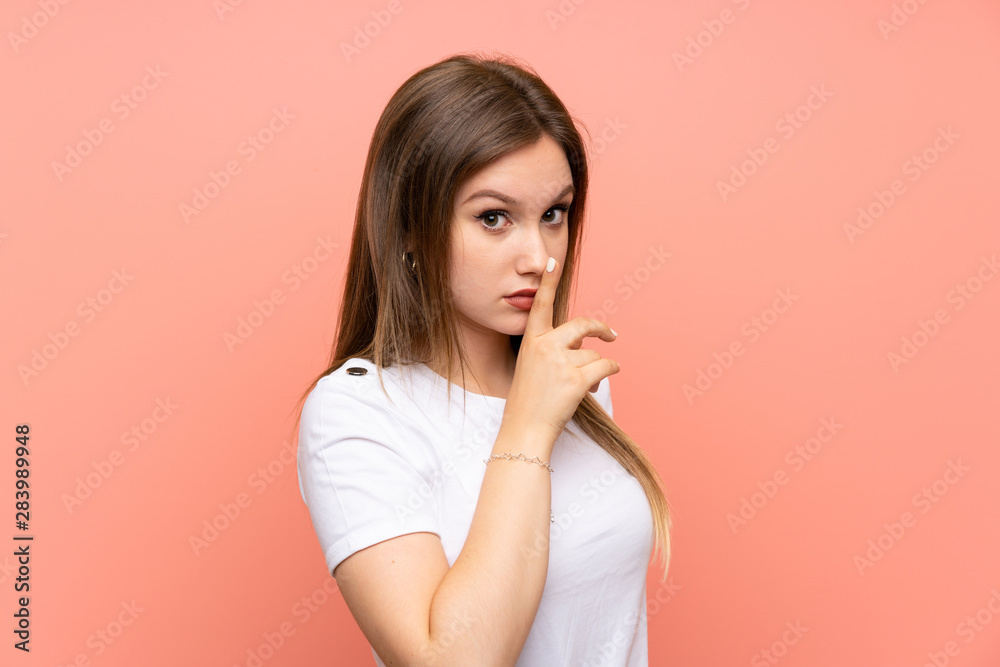 Teenager girl over isolated pink wall doing silence gesture Teenager girl over isolated pink wall doing silence gesture