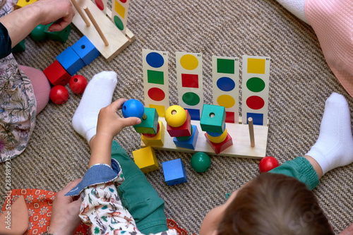 Children with moms playing on the floor. Educational games for kids