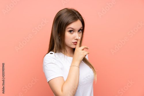 Teenager girl over isolated pink wall doing silence gesture