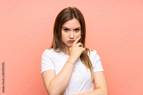 Teenager girl over isolated pink wall thinking an idea