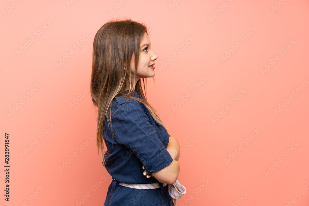 Teenager girl over isolated pink background in lateral position Teenager girl over isolated pink background in lateral position