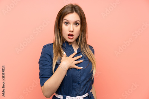 Teenager girl over isolated pink background surprised and shocked while looking right