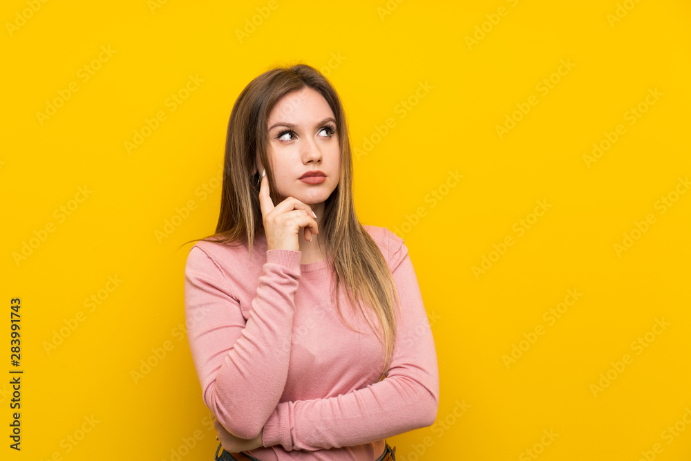 Teenager girl over isolated yellow background thinking an idea Teenager girl over isolated yellow background thinking an idea