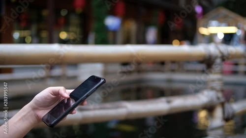 Cropped hand of woman used mobile phone blurred background