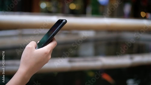 Cropped hand of woman used mobile phone blurred background