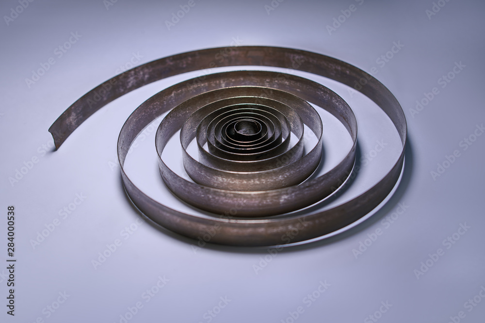 Industrial concept. Old metal spiral on nice blue background Industrial concept. Old metal spiral on nice blue background