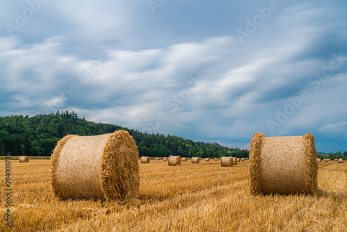 Strohballen unter einem fließenden Wolkenhimmel