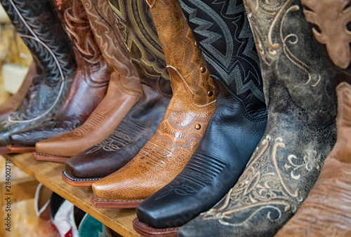 Photo Original western style photograph of cowboy boots all lined up