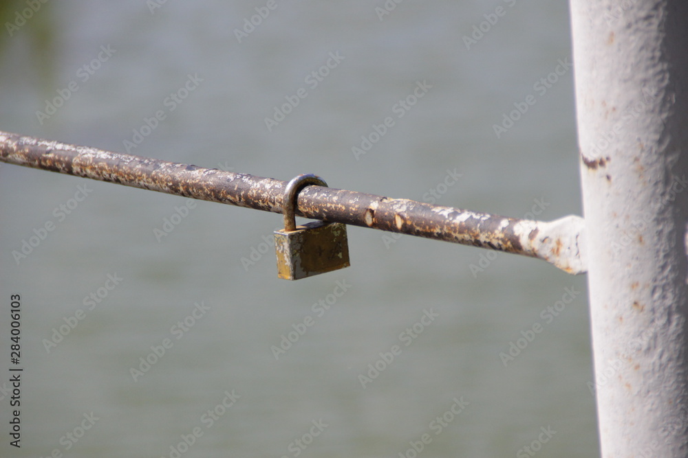 small rusty lock hanging on the iron fence. love, relationships, psychology small rusty lock hanging on the iron fence. love, relationships, psychology
