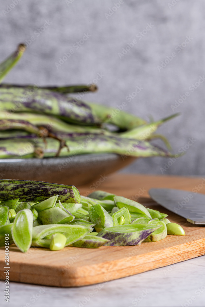 Heap of green beans on a rustic wooden table top view. Cutting board with green beans Heap of green beans on a rustic wooden table top view. Cutting board with green beans