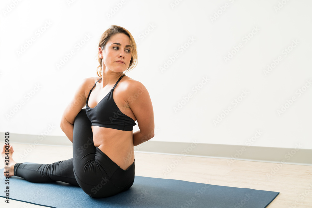Fototapeta premium Beautiful Caucasian Woman With Twisted Exercise At Studio