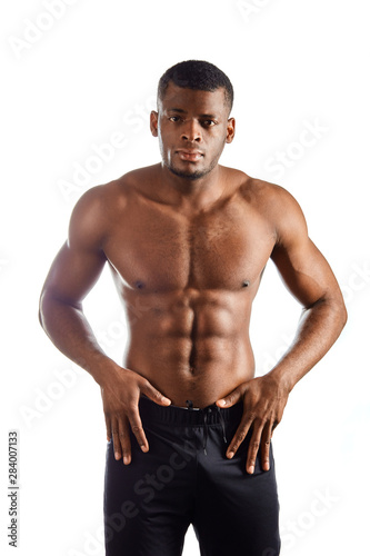 good looking male model with palms on his hips, showing off his physique against white background.close up photo.