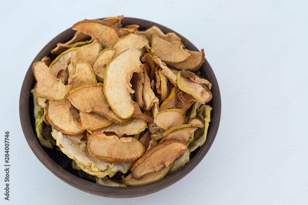 Apple quince chips in a brown clay bowl isolated healthy food Apple quince chips in a brown clay bowl isolated healthy food