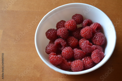 raspberries in the small white bowl. fresh organic berries.