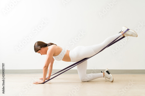 Active Woman Exercising With Resistance Bands On Studio