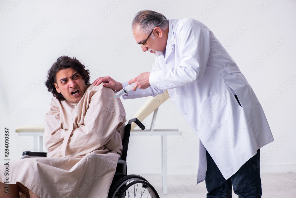 Old male doctor psychiatrist and patient in wheel-chair Old male doctor psychiatrist and patient in wheel-chair