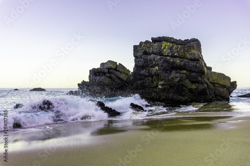 Ocean wave and rock cliffs on sandy beach, PortugalOcean wave and rock cliffs on sandy beach, PortugalOcean wave and rock cliffs on sandy beach, Portugal
