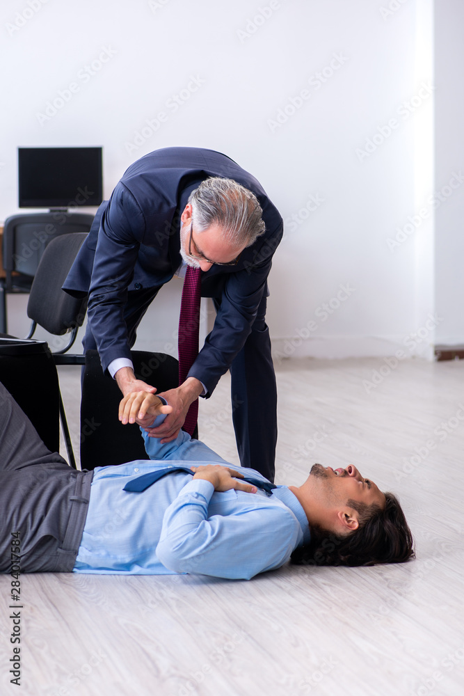 Male employee suffering from heart attack in the office Male employee suffering from heart attack in the office