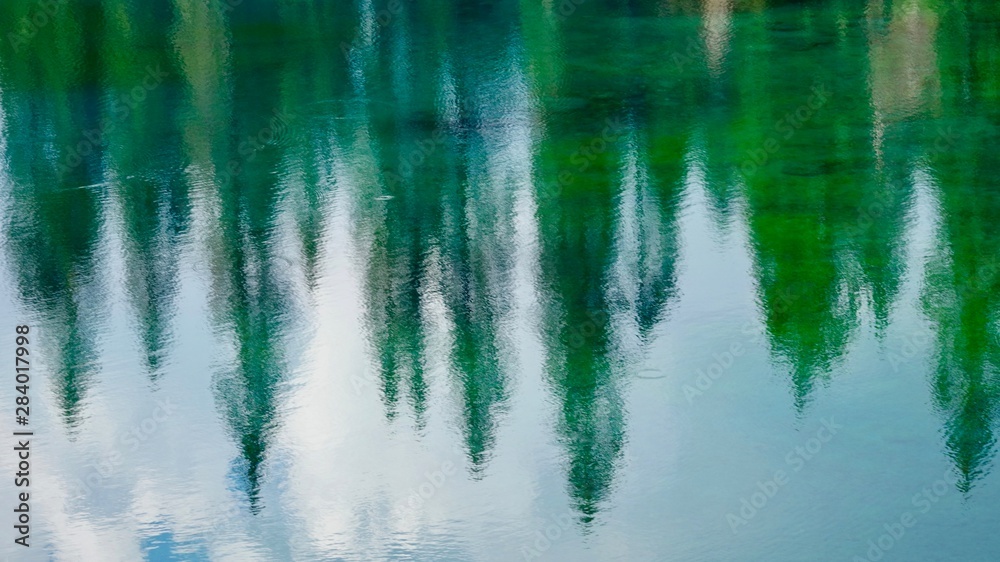 Berge und Bäume spiegeln sich im grünen Karersee in Südtirol Berge und Bäume spiegeln sich im grünen Karersee in Südtirol