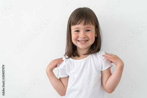 Canvas Print Joyful child in a white T-shirt on a light background