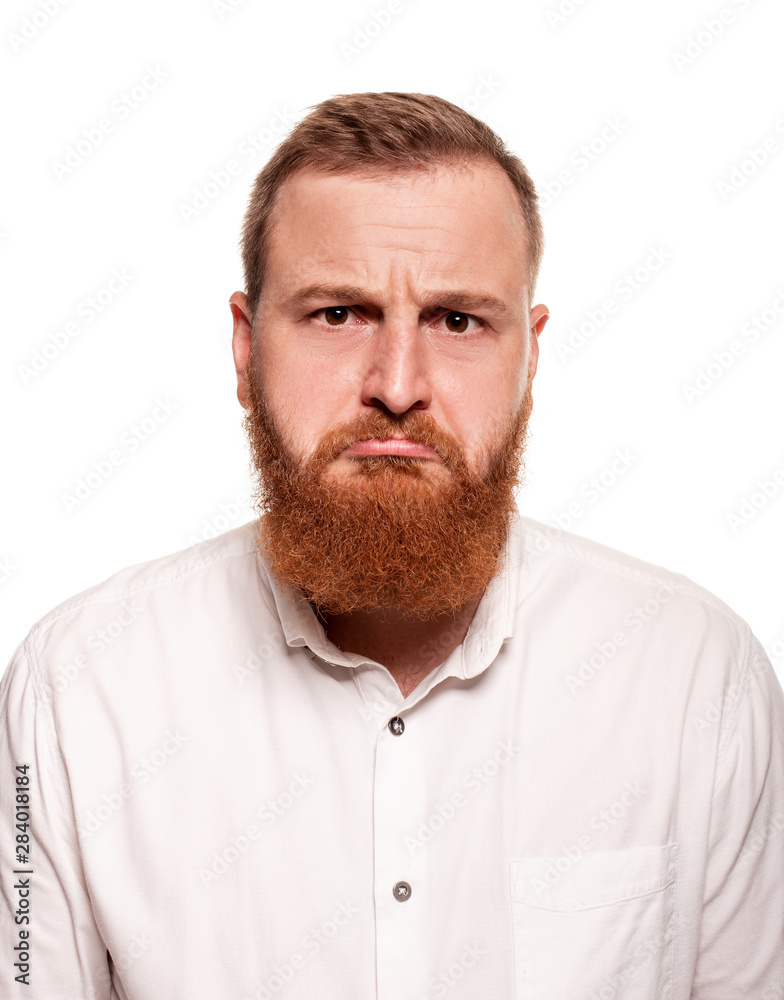 Portrait of a young, chubby, redheaded man in a white shirt making faces at the camera, isolated on a white background Portrait of a young, chubby, redheaded man in a white shirt making faces at the camera, isolated on a white background