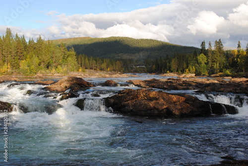 Stunning blue River with rocks and forest with hill