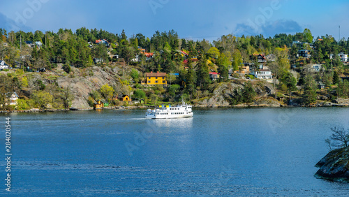Commuter ferry entering to Skurusundet strait in the Stockholm archipelago at a sunny spring evening.