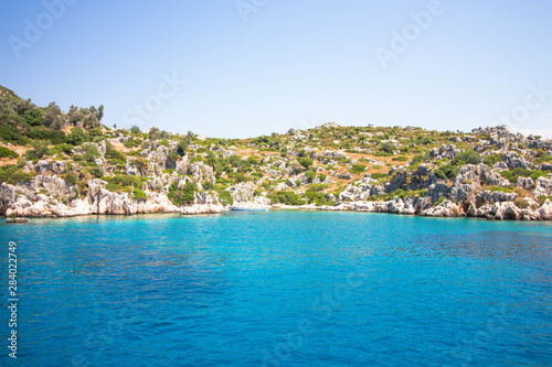 Fototapeta Naklejka Na Ścianę i Meble -  View of the sea and the ancient ruins of the city from a yacht. The water is very clear with a blue tint. Wonderful outdoor activities.