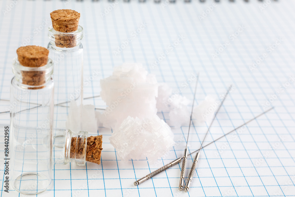Fototapeta premium Medical Glass container with cork stopper end Needles for medical acupuncture are on the notebook.
