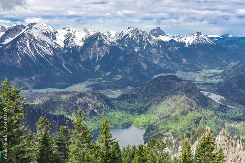 View from the top of Mount Tegelberg on a ridge of German mountains. Beautiful snowy mountain landscape of Bavaria.