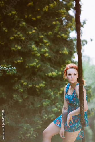 Fototapeta Naklejka Na Ścianę i Meble -  Young beautiful redhead woman on the rope bridge.