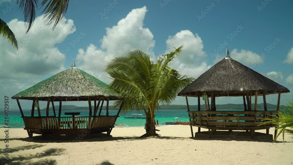 Tropical beach with bungalows and blue sea. Summer and travel vacation concept