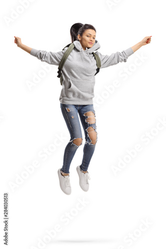 Female student with backpack jumping