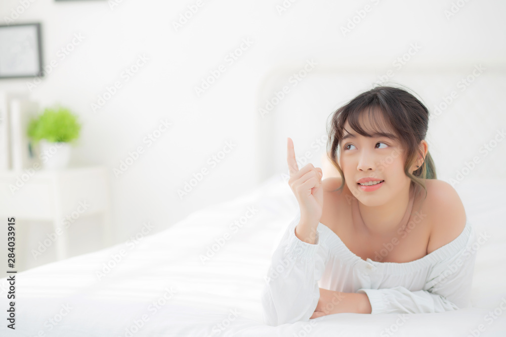 Portrait beautiful young asian woman smile wake up healthy and wellness at morning, beauty asia girl lying and pointing something skin care and makeup cosmetic with happy, lifestyle and relax concept. Portrait beautiful young asian woman smile wake up healthy and wellness at morning, beauty asia girl lying and pointing something skin care and makeup cosmetic with happy, lifestyle and relax concept.