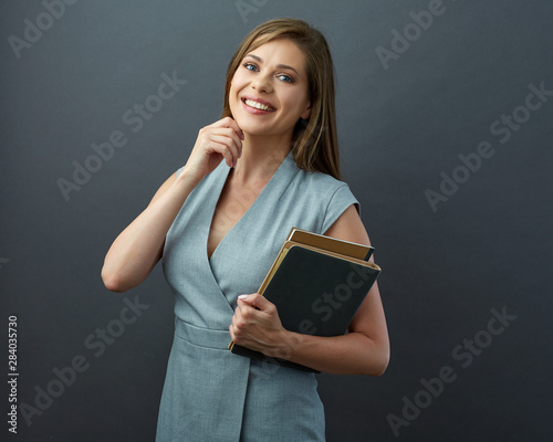 Smiling woman teacher holding book.
