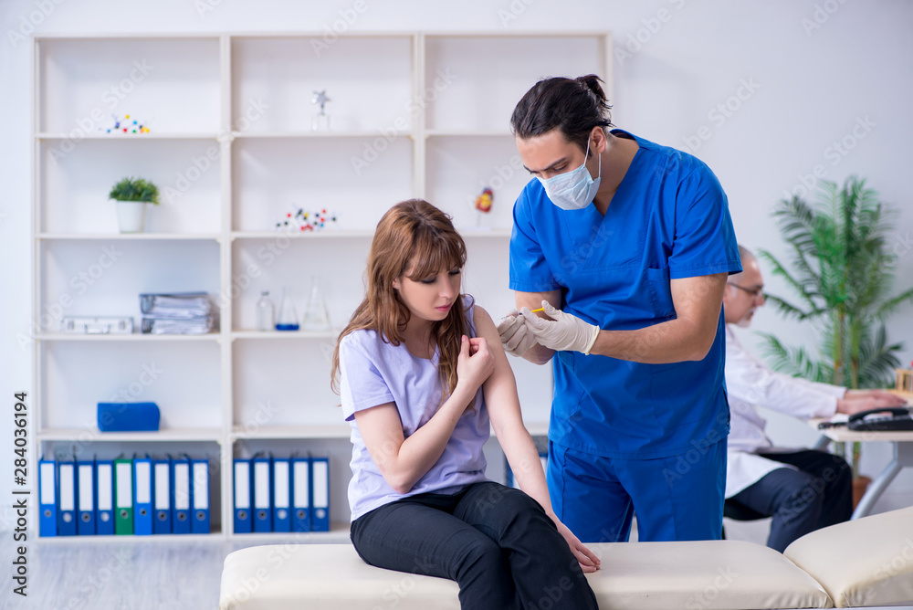 Fototapeta premium Two doctors examining young woman