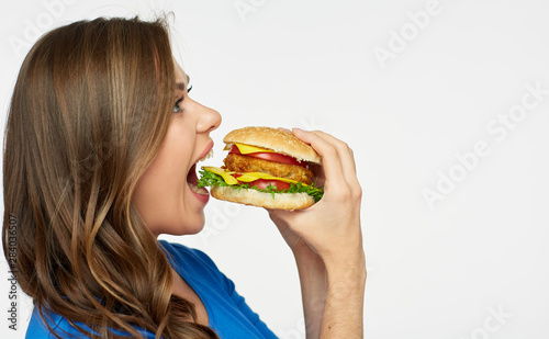 young woman eating fast food burger.