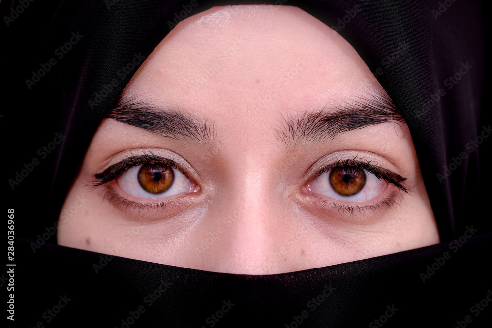 Half portrait of hijab muslim woman, closeup of muslim girl and she wearing black scarf or veil Half portrait of hijab muslim woman, closeup of muslim girl and she wearing black scarf or veil