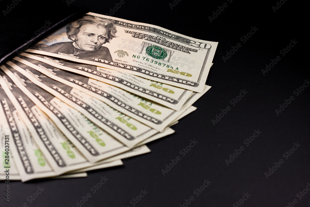 Twenty dollar bill. 20 dollar bill. Image isolated on black background. Fan-shaped tickets introduced in a wallet. Twenty dollar bill. 20 dollar bill. Image isolated on black background. Fan-shaped tickets introduced in a wallet.