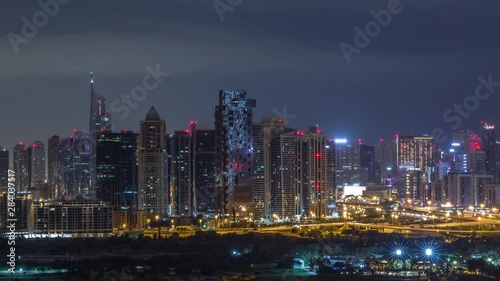 Wallpaper Mural Jumeirah lake towers and Dubai marina illuminated skyscrapers and golf course during all night timelapse with blinking lights, Dubai, United Arab Emirates. Aerial view from Greens district Torontodigital.ca