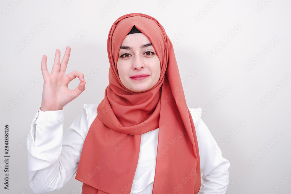 Happy muslim woman showing ok or okay sign with fingers Happy muslim woman showing ok or okay sign with fingers