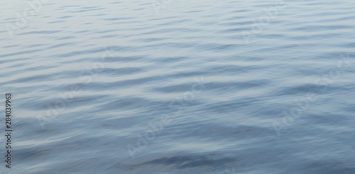 The smooth light blue river water surface as a background